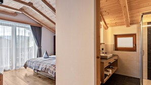 A bedroom with a bed, a window with curtains, and a wooden ceiling.