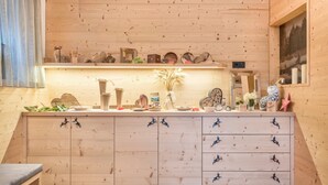 A wooden interior with a kitchen counter, cabinets, and decorative items. - Holiday Apartment 'Hatzes App Raschötz' with Mountain View, Balcony and Wi-Fi (Lajen)
