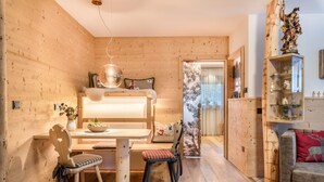 A cozy wooden interior with a dining area, a sofa, and a decorative statue. - Holiday Apartment 'Hatzes App Raschötz' with Mountain View, Balcony and Wi-Fi (Lajen)