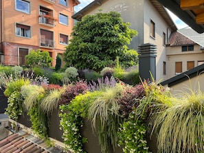 Un immeuble résidentiel doté d’un mur d’enceinte, d’un grand arbre et d’un escalier.