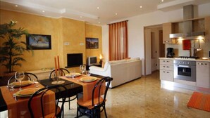 Una sala moderna con comedor, cocina y un amplio ventanal con cortinas.