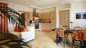 Una cocina moderna con comedor, sofá y mesa puesta para comer.