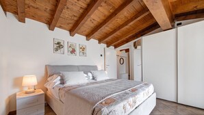 Ein Schlafzimmer mit Bett, Nachttisch und Wandbild.