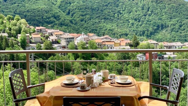 Ein Tisch ist für ein Frühstück gedeckt, mit Blick auf die Berge.