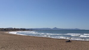 A beach with a clear sky, calm sea, and distant mountains. - Holiday Home 'Casa Babut' with Pool, Garden and Terrace (Pedreguer)