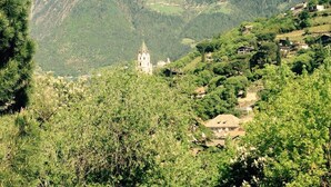 Eine Berglandschaft mit einer Kirche und verstreuten Häusern.