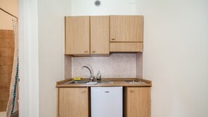 A compact kitchen with wooden cabinets, a sink, and a white refrigerator. - Residence Hubertus Apartment 5 with  Balcony & Wi-Fi (Meran)