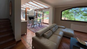 Un grand espace de vie comprenant un canapé, une table à manger et un barbecue.