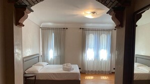 Une chambre d’hôtel avec un lit, une chaise et un ventilateur de plafond.