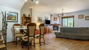 Una sala de estar con chimenea, televisor y sofá.