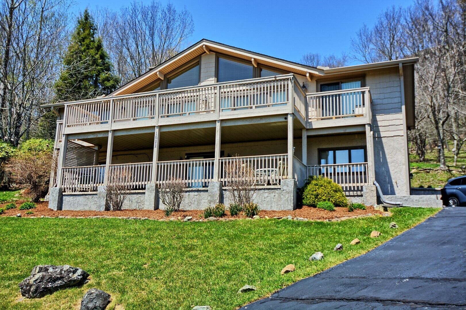 A two-story house with a balcony on the upper floor and a covered porch on the ground floor.