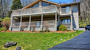 A two-story house with a balcony on the upper floor and a covered porch on the ground floor. - Stunning 3BR chalet in Seven Devils, NC, featuring mountain views and a hot tub. (Seven Devils)