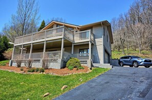 A two-story house with a balcony, a driveway, and a parked car. - Stunning 3BR chalet in Seven Devils, NC, featuring mountain views and a hot tub. (Seven Devils)