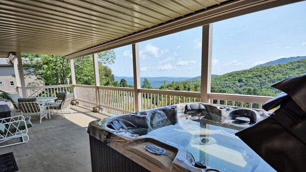 A hot tub on a covered patio with a view of mountains. - Stunning 3BR chalet in Seven Devils, NC, featuring mountain views and a hot tub. (Seven Devils)