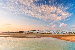 A coastal town with buildings, a beach, and a water body.