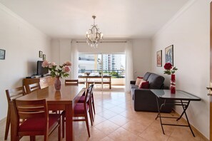 Un coin repas avec une table, des chaises et un vase de fleurs.
