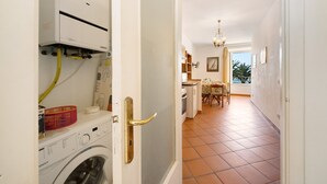 Un área de lavandería con lavadora, secadora y una puerta con picaporte de latón.