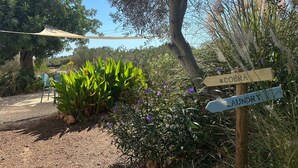 A garden with a signpost indicating directions to 'Cobra' and 'Launy'. - Holiday Home 'Casa Cobra' with Mountain View, Shared Pool, Garden & Wi-Fi (Moncarapacho)