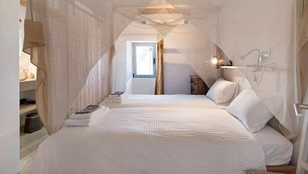 A bedroom with a large bed, a bedside table, a window, and a canopy. - Holiday Home 'Casa Cobra' with Mountain View, Shared Pool, Garden & Wi-Fi (Moncarapacho)