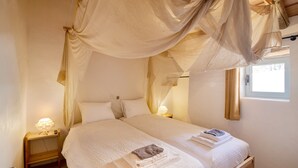 A bedroom with a canopy bed, bedside lamps, and a window. - Holiday Home Casa Burro with Mountain View, Shared Pool, Garden & Wi-Fi (Moncarapacho)
