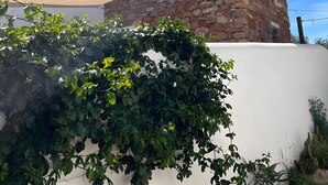 A stone building with a sloped roof, a small window, and a white wall. - Holiday Home 'Casa Osga' with Mountain View, Shared Pool, Terrace & Wi-Fi (Moncarapacho)