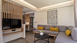 A modern living room with a grey sofa, a black coffee table, a flat-screen TV, and a decorative wall piece. - Paligremnos Residence I, sublime beachside retreat (Plakias)