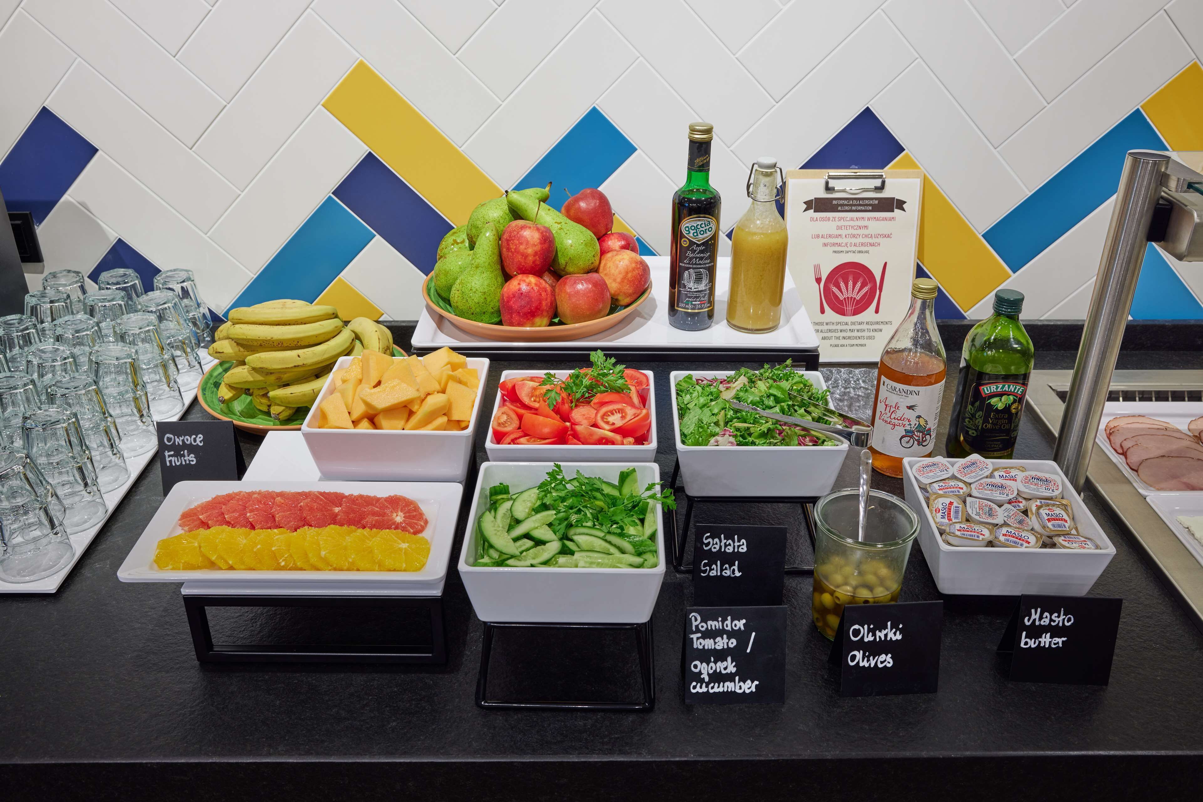 A buffet with various food items including fruits, salads, and condiments.