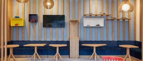 Un interior moderno con una paleta de colores azul y madera, que incluye un sofá, mesas y estanterías decorativas.