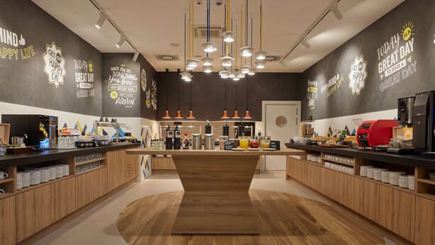Una cocina moderna con armarios de madera, una isla central y diversos electrodomésticos.