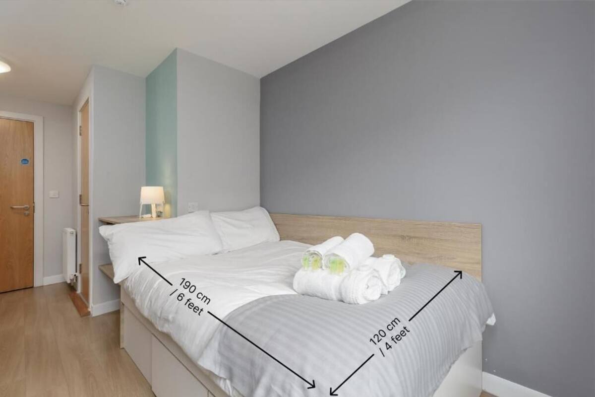 A bedroom with a bed measuring 190 cm / 6 feet in length and 120 cm / 4 feet in width.