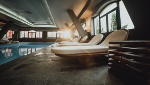 Ett poolområde med solstolar och en solbädd.