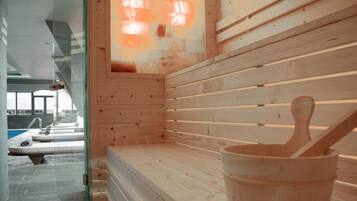 Een sauna met houten banken en een houten emmer.