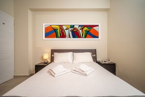 A neatly made bed with white linens, a bedside lamp, and a phone on the nightstand. - 2 Bed House - Sleeps 5 - Garden - Parking - Wifi (Apokoronas)