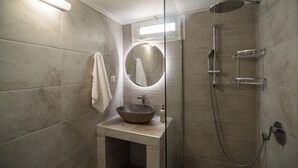 A modern bathroom with a large round mirror, a vessel sink, and a walk-in shower. - 2 Bed House - Sleeps 5 - Garden - Parking - Wifi (Apokoronas)