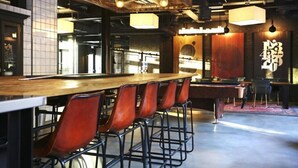A bar area with a long counter and several stools. - JOIVY at VITA Fountainbridge - Adults only (Edinburgh)
