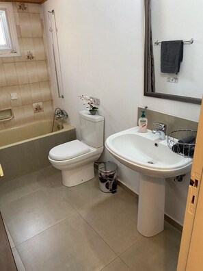 A bathroom with a toilet, sink, and bathtub. - City Comfortable Apartment (Larnaca)