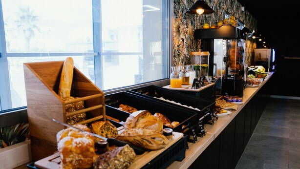 A buffet with various food items and a coffee machine.