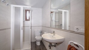 A modern bathroom with a shower, toilet, and sink. - Hostal Castell de Lô (Alayor)