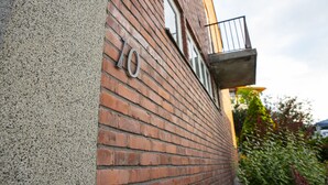 A brick building with a balcony and a window. - Tiglkåk - Hostel (Rauma)