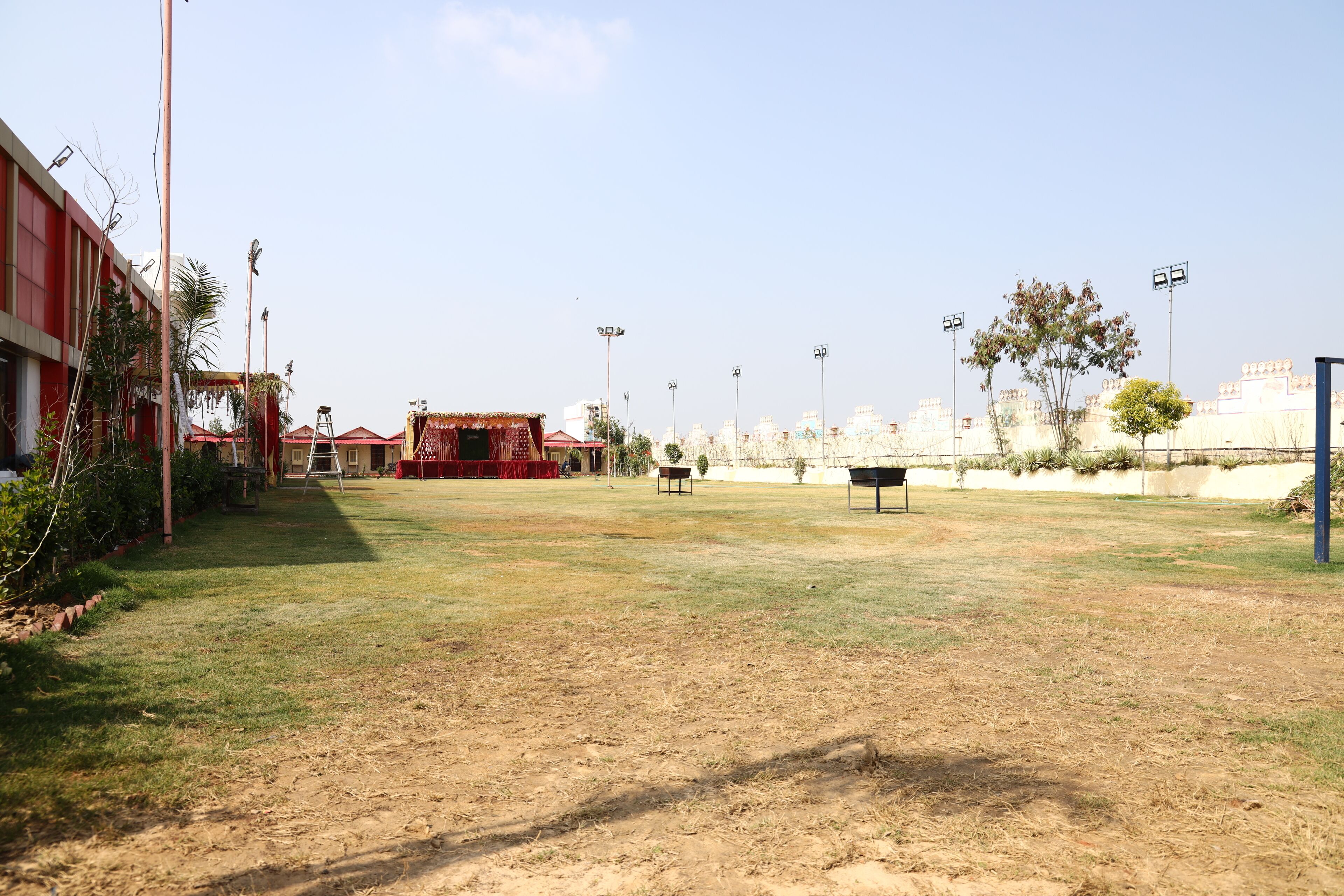 Un espacio al aire libre con césped, un escenario y un edificio de fachada roja.