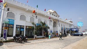 A white building with multiple flags, a restaurant sign, and parked motorcycles.