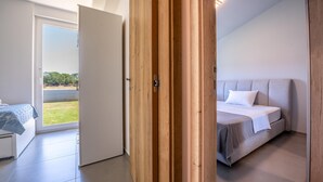 A bedroom with a bed, a wooden wardrobe, and a sliding glass door leading to a balcony. - Holiday house Ana (Fažana)