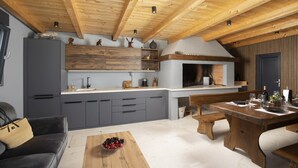 A modern kitchen with wooden beams, grey cabinets, and a built-in oven. - Holiday house Ana (Fažana)