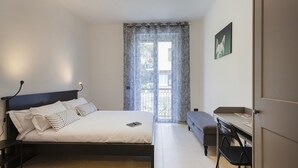Une chambre à coucher comprenant un lit, une table de chevet et un bureau avec une chaise.