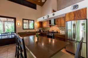 A modern kitchen with a central island, stainless steel appliances, and wooden cabinetry.