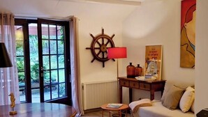 Ein gemütliches Wohnzimmer mit einem Holztisch, einer Couch, einem Teppich und einer Schiffslenkrad-Dekoration an der Wand.