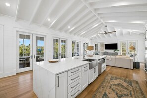 A spacious kitchen with a large island, white cabinetry, and a ceiling fan. - EXQUISITE LUXURY HOME w/ POOL, LSV, BIKES! NEXT TO CAMP WATERCOLOR! Pet Friendly! (Santa Rosa Beach)