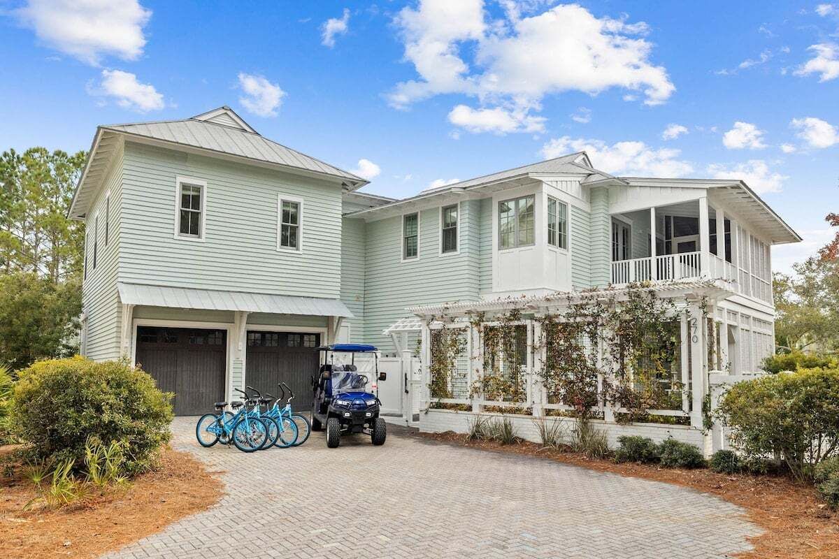 Ein zweistöckiges Haus mit Garage, überdachter Veranda und Auffahrt.
