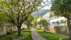 A stone pathway leading to a building with a white facade and a mountain in the background. - Apa Mountain Lodge (Konyaalti)