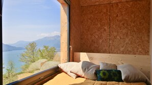 A bedroom with a large window offering a view of a lake and mountains. - COTTAGE ORSOLA by KlabHouse-4pax w/AC and Lakeview (Dolo)